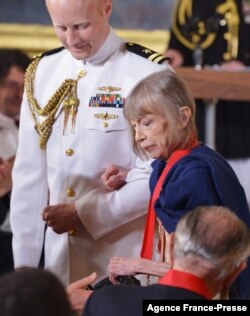 2012 National Humanities Medal recipient author Joan Didion returns to her seat after receiving her medal during a ceremony in the East Room of the White House on July 10, 2013.