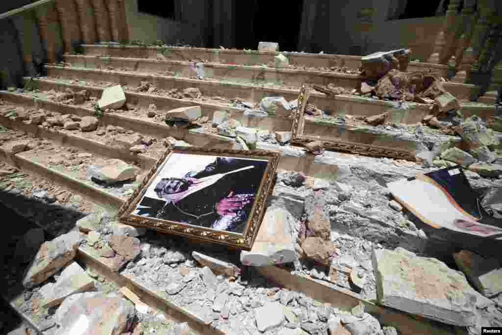 A picture of Saudi Arabia&#39;s King Salman bin Abdulaziz lies amidst the debris at the damaged headquarters of the Saudi Cultural Center. The damage to the building was caused by an April 20 airstrike that also hit a nearby army weapons depot, in Sana&#39;a, Yemen, April 21, 2015.