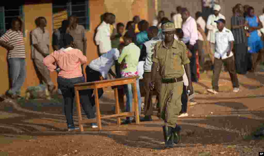 Patrouille d&#39;un policier alors que les électeurs attendent patiemment devant un bureau de vote où devait commencer les votes le 18 février 2016