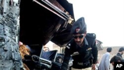 Pakistani security officials collect evidence near a vehicle targeted by a suicide attacker in Kohat, 60 kilometers south of Peshawar, Pakistan, Dec. 8, 2010.
