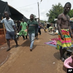 Ethnic Gueres carry a dead relative inside a temporary refugee camp set up at a Catholic church in Duekoue, Ivory Coast, May 2011.