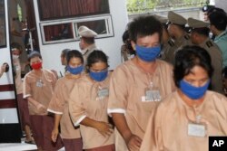 FILE - Female suspects allegedly involved in human trafficking of Rohingya migrants file into the Criminal Court in Bangkok, Thailand, Nov. 10, 2015.