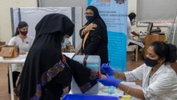 A woman hold her arm after receiving Covishield COVID-19 vaccine at a vaccination center in Mumbai, India, Monday, Nov. 29, 2021. (AP Photo/Rafiq Maqbool)