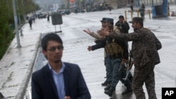 FILE - Afghan security forces shout at journalists at the site of a deadly Taliban-claimed suicide attack in Kabul, Afghanistan, April 19, 2016.