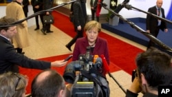 FILE - German Chancellor Angela Merkel speaks with reporters as she arrives for an EU-Turkey summit at the EU Council building in Brussels, Nov. 29, 2015. 