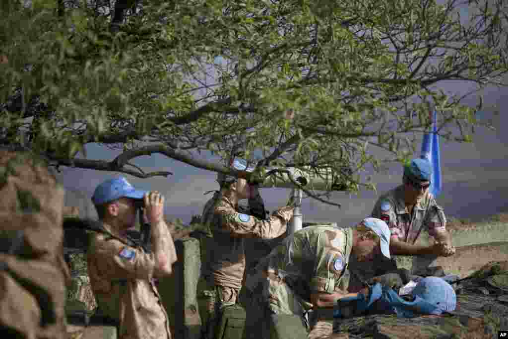 U.N. peacekeepers from the United Nations Disengagement Observer Force, also known as UNDOF, observe Syria's Quneitra province at an observation point on Mt. Bental in the Israeli-controlled Golan Heights, overlooking the border with Syria, Aug. 29, 2014.