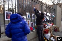 Volunteers with the 'Wall of Hope Foundation' build a memorial wall for the victims of New York City's deadliest fire in three decades, in the Bronx borough of New York, Jan. 12, 2022.