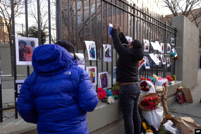 Volunteers with the 'Wall of Hope Foundation' build a memorial wall for the victims of New York City's deadliest fire in three decades, in the Bronx borough of New York, Jan. 12, 2022.