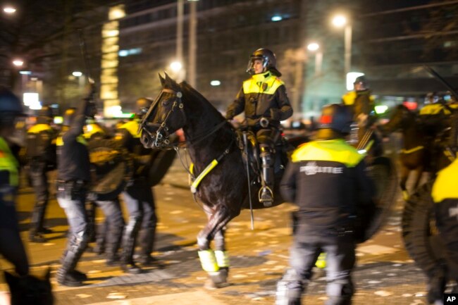 FILE - Dutch riot police battle pro Erdogan demonstrators after riots broke out at the Turkish consulate in Rotterdam, Netherlands, March 12, 2017.