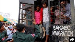 Cambodian migrant workers get off from a Thai truck upon their arrival from Thailand at Cambodia-Thai international border gate in Poipet, Cambodia, Tuesday, June 17, 2014. The number of Cambodians who have returned home from Thailand this month after a threatened crackdown on foreigners working illegally has topped 160,000, a Cambodian official said Monday. Thai officials insist the cross-border movement is voluntary and is not forced repatriation. They say Thai military and government resources were used to transport workers who decided to return home after being laid off because they were working illegally. (AP Photo/Heng Sinith)