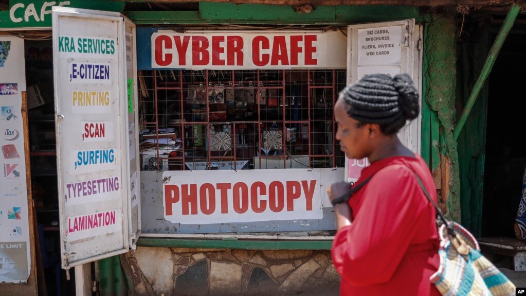 A pedestrian walks past an internet cafe in the low-income Kibera neighborhood of Nairobi, Kenya Wednesday, Sept. 29, 2021. (AP Photo/Brian Inganga)