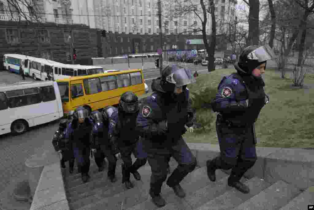 A police unit moves from blocking a street in front of a government building in Kyiv, Dec. 5, 2013.