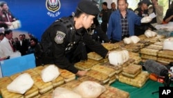 FILE - Thai policemen arrange packages of methamphetamine on a table before a press conference in Bangkok, Thailand, Feb. 15, 2013.