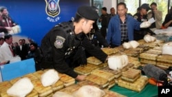 FILE - Thai policemen arrange packages of confiscated methamphetamine on a table before a press conference in Bangkok, Thailand, Feb. 15, 2013.