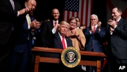 El presidente Donald Trump, rodeado por miembros de su gabinete y partidarios en Miami,celebra el decreto por el que autoriza el cambio de política hacia Cuba.