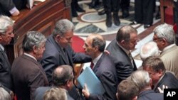 French Labor Minister Eric Woerth, center, is congratulated by members of parliament after the vote on retirement reform at the National Assembly in Paris, 27 October 2010