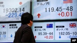 Một người đàn ông đang xem bảng ghi tỷ giá giao dịch ngoại tệ ở Tokyo, Nhật Bản.