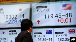 Papan yang menunjukkan nilai pertukaran mata uang dan indeks saham Nikkei di Tokyo. (Foto: Dok)