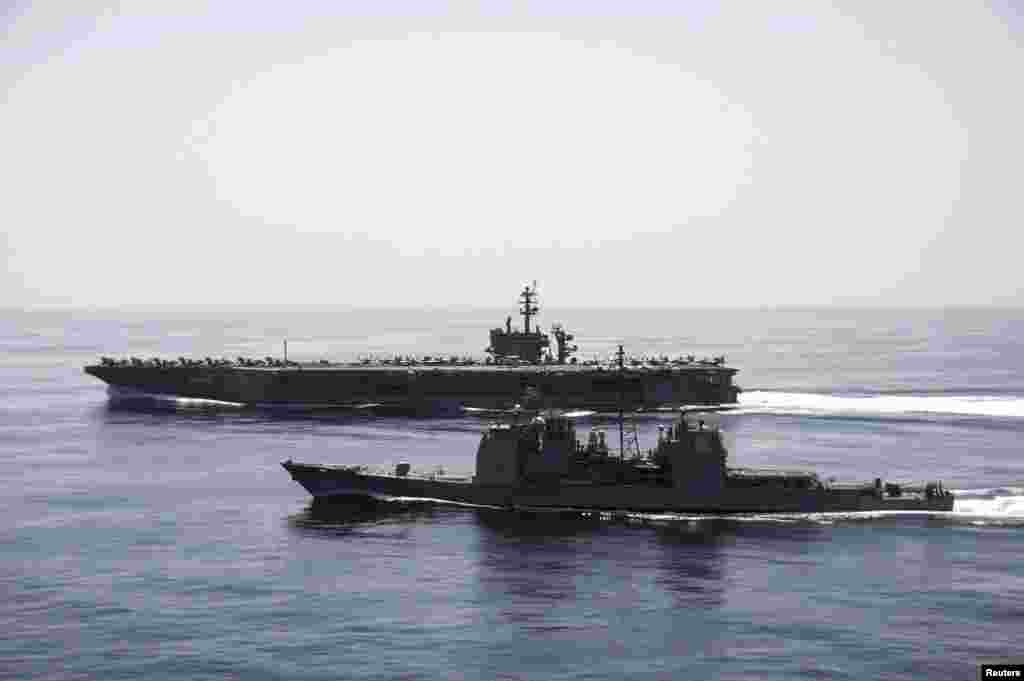 Kapal USS Theodore Roosevelt (CVN 71) pembawa pesawat dan kapal pemandu rudal USS Normandy (CG 60) melakukan operasi maritim di Laut Arab (21/4). (U.S. Navy)