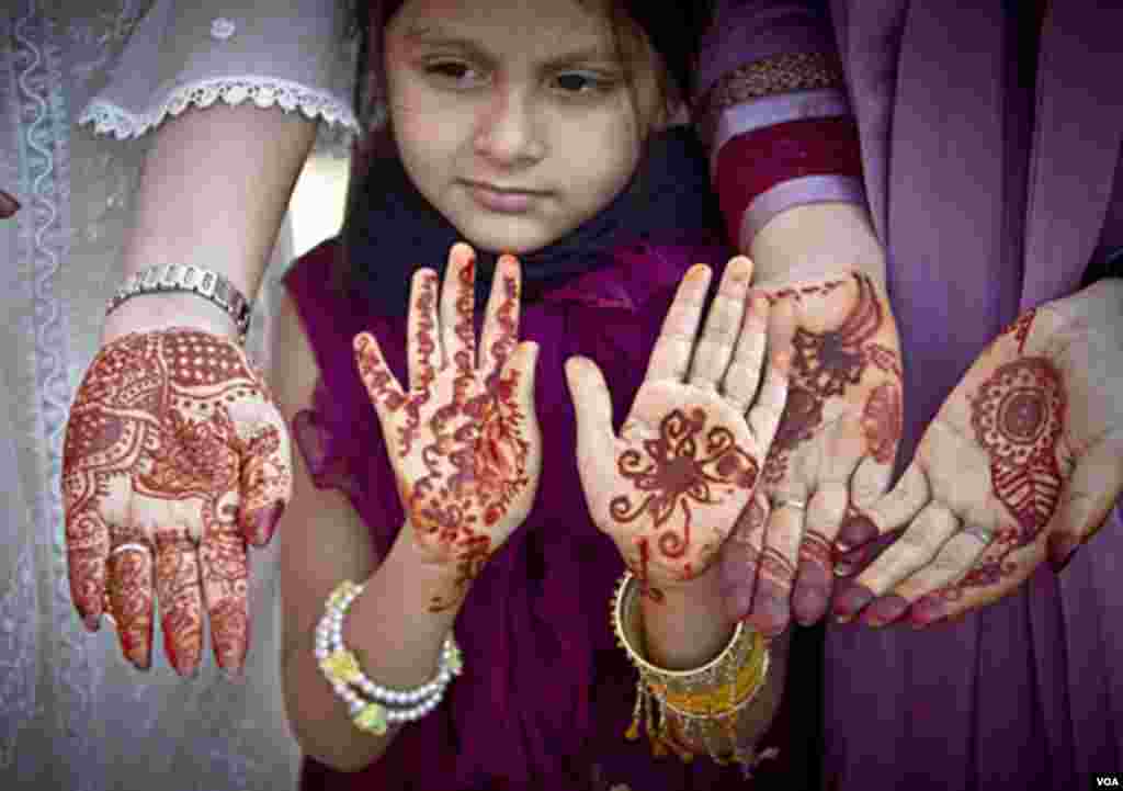 Muslim women and a girl show their hands decorated with Henna, after Eid al-Fitr prayers in Bucharest, Romania, Aug. 30, 2011. AP