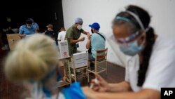 Los trabajadores de la salud administran a las personas una dosis de la vacuna china Sinopharm en Caracas, el 3 de septiembre de 2021.