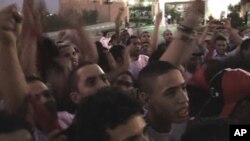 Libyans in Martyr's Square in Tripoli watch their national football team compete under the country's new flag, Saturday, Sept. 3, 2011.