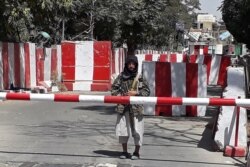 Seorang pejuang Taliban berjaga di pintu masuk Markas Besar Kepolisian di Ghazni, 12 Agustus 2021. (AFP)