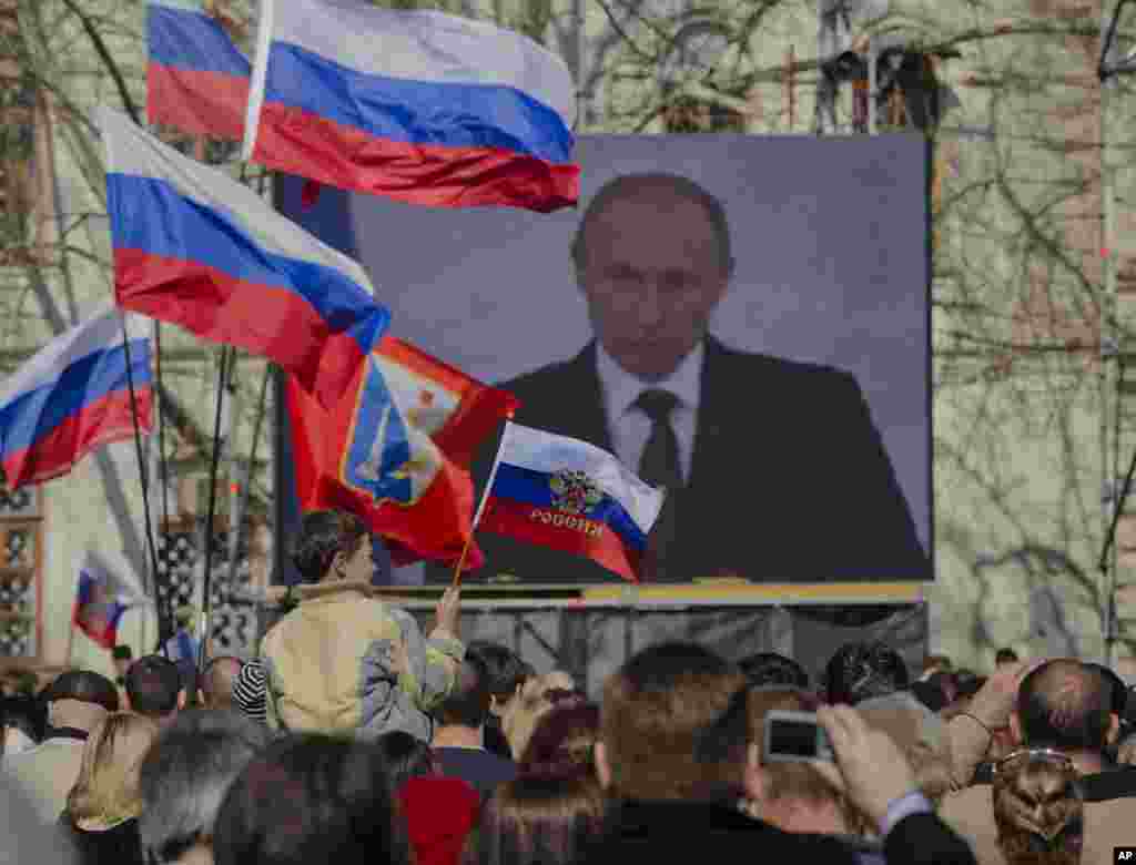 Những người thân Nga theo dõi bài phát biểu của Tổng thống Putin trên truyền hình tại&nbsp;bán đảo Crimea, ngày 18/3/2014.
