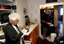 Pamela Arneson writes down the food that was lost as Eric Arneson, 72, cleans out the refrigerator after returning to their home for the first time in almost two weeks in Montecito, Calif., Jan. 25, 2018.