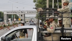 Pasukan paramiliter Pakistan menjaga pintu masuk utama pangkalan udara di Kamra, provinsi Punjab. Taliban melakukan serangan atas pangkalan ini sebelum subuh hari Kamis (16/8).