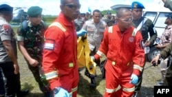 Para anggota polisi dan TNI AD membawa jenazah para korban tewas akibat serangan kelompok bersenjata, di Timika, Papua, Kamis (6/12).