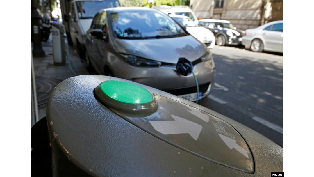 FILE - An electric car is being charged in a Paris street, France, Sept. 12, 2017.