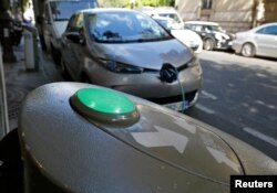 FILE - An electric car is being charged in a Paris street, France, Sept. 12, 2017.