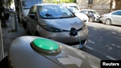 An electric car is being charged in a Paris street, France, Sept. 12, 2017. 