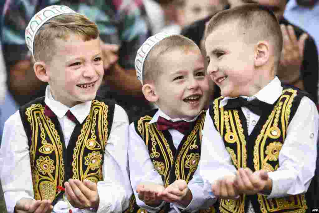 Young Kosovo muslims take part in a prayer during a celebration of Eid al-Fitr marking the end of the fasting month of Ramadan at the Sulltan Mehmet Fatih mosque in Pristina.