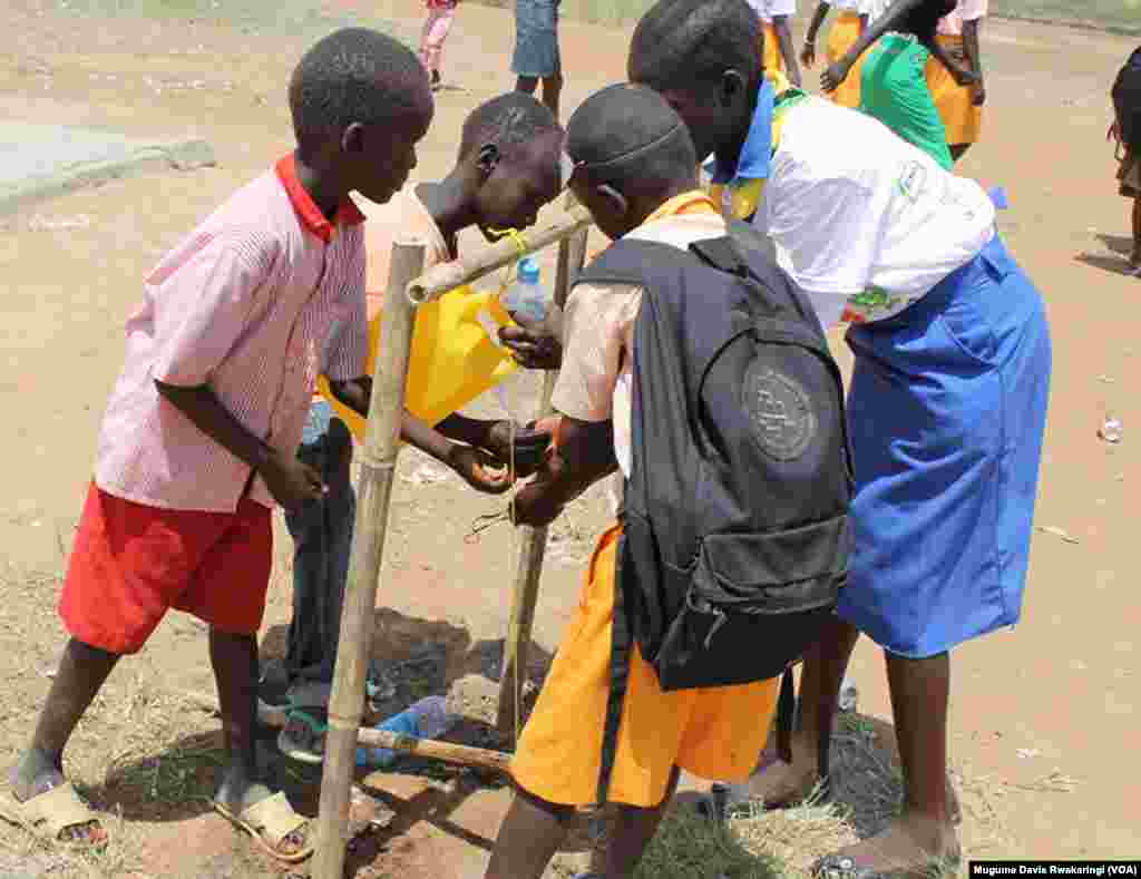 South Sudanese children wash their hands using water from a jerry can, in Juba October 2013.