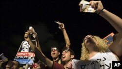 Israelis shout slogans as they wave fake bank notes during a rally in Tel Aviv against rising rent and property prices in Israel, July 23, 2011