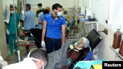 A woman affected by what activists say was a gas attack on the town of Telminnes breathes through an oxygen mask at Bab al-Hawa hospital, where she was transferred to, close to the Turkish border April 21, 2014. 