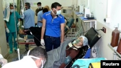 A woman affected by what activists say was a gas attack on the town of Telminnes breathes through an oxygen mask at Bab al-Hawa hospital, in Syria, April 21, 2014.