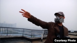 Josh Fox gestures to the oppressive smog from a rooftop in Beijing. (Credit: International WOW Company)