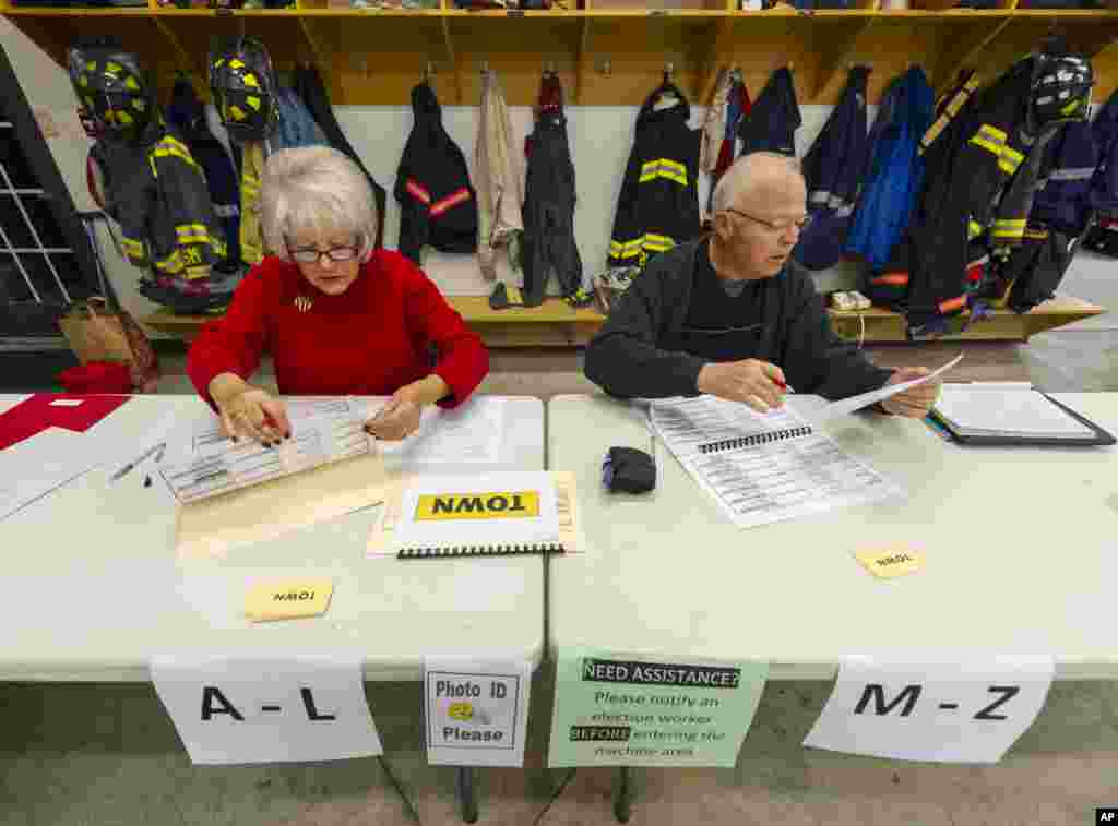 Poll clerk Kay McClain, left, and Duane Fleener, prepare the voter lists as they get ready for the doors to open at 6 a.m. Nov. 4, 2014, at their poll location in a fire station in Avon, Indiana.