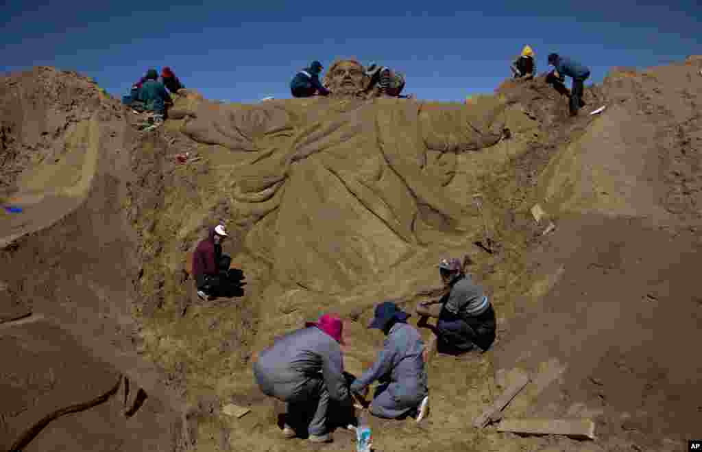En Oruro, Bolivia, artistas trabajan en una escultura de arena de Jesucristo en las celebraciones de Semana Santa en Arenal de Cochiraya. 200 artistas se reunieron para el evento de Viernes Santo para construir esculturas de arena basadas en las parábolas de Jesús. Foto AP.