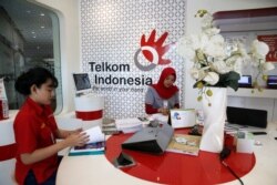 Sejumlah karyawan PT Telekomunikasi Indonesia (Telkom) di Plasa Telkom, 30 April 2018. (Foto: Beawiharta/Reuters)