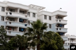 Workers' clothes hang on the balcony of a company-owned apartment adjacent to a shoe factory owned by the Huajian Group, which has made shoes for the Ivanka Trump brand, in Ganzhou in southern China's Jiangxi province, June 18, 2017.