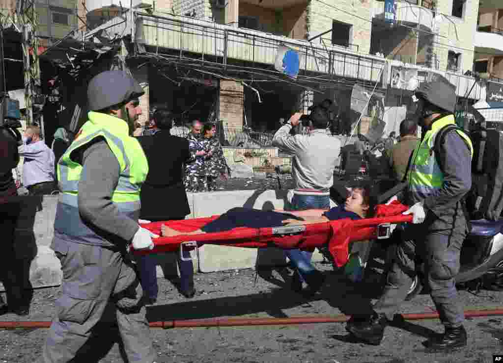 Lebanese civil defense workers carry an injured girl at the site of an explosion, near the Kuwaiti Embassy and Iran&#39;s cultural center, in the suburb of Beir Hassan, Beirut, Lebanon, Feb. 19, 2014.