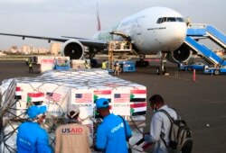 FILE - Aid workers check a shipment of vaccines against the coronavirus sent to Sudan by the Covax vaccine-sharing initiative, shortly after an Emirates plane landed at the airport in the capital Khartoum, on October 6, 2021.