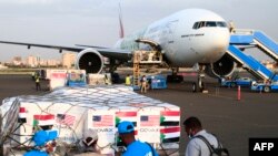 Staf badan bantuan AS memeriksa pengiriman vaksin coronavirus di Sudan lewat program Covax, tak lama setelah pesawat Emirates mendarat di bandara di ibu kota Khartoum, 6 Oktober 2021.