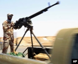 A rebel fighter mans a heavy machine-gun as he takes his position on the frontline along the western entrance of Ajdabiya, Libya, April 23, 2011