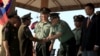 FILE - Cambodian Defense Minister Tea Banh, second left, shakes hands with a Chinese army adviser during a graduation ceremony at the Army Institute in Kampong Speu province, March 12, 2015. 