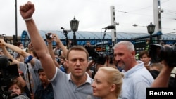 Russian opposition leader Alexei Navalny (L) addresses his supporters after arriving from Kirov, with his wife, Yulia, standing nearby, at a railway station in Moscow, July 20, 2013.